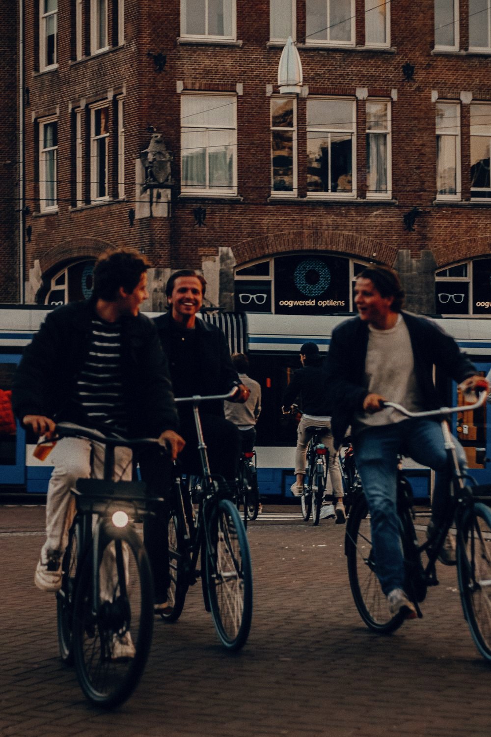 Jongeren op de fiets langs de tram in Amsterdam