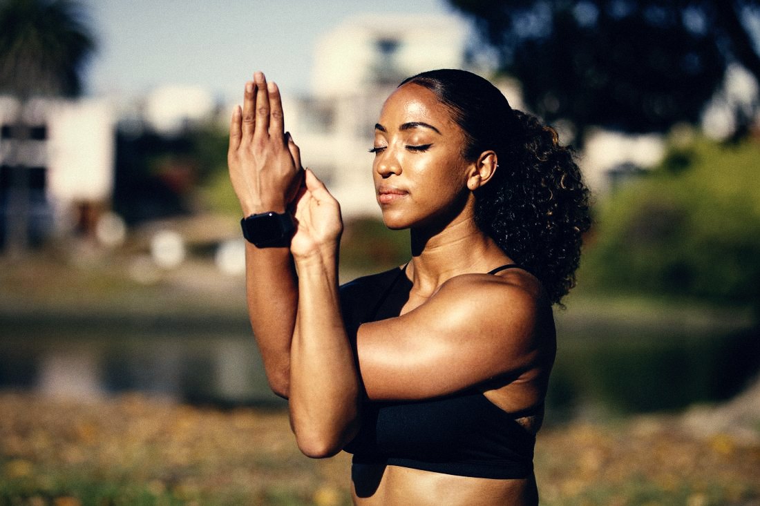 Een vrouw in rust tijdens yoga buiten