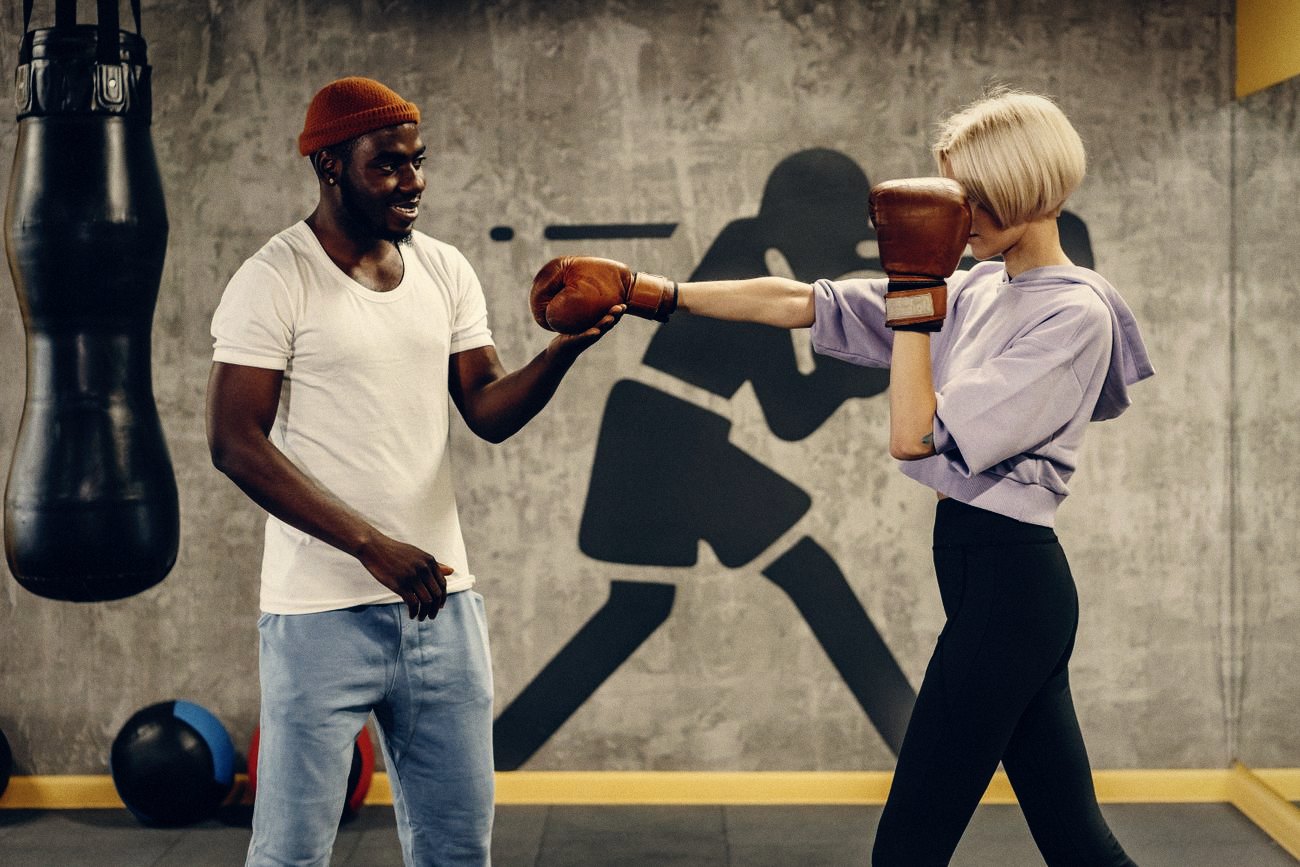 Een trainer geeft een bokstraining in een sportschool